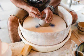 Une photographe en paysage d'un artisan potier qui tourne sa pièce avec précision et dextérité.