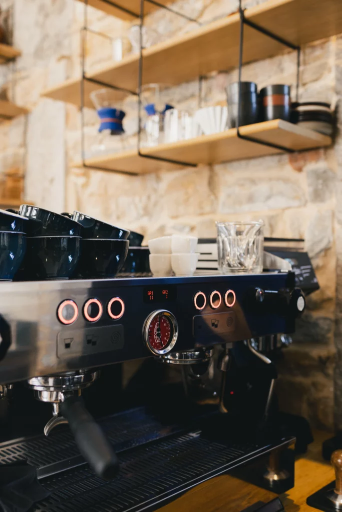 La machine à café qui n'attend qu'à être utilisé dans un lieu brut avec des pierres aux murs.