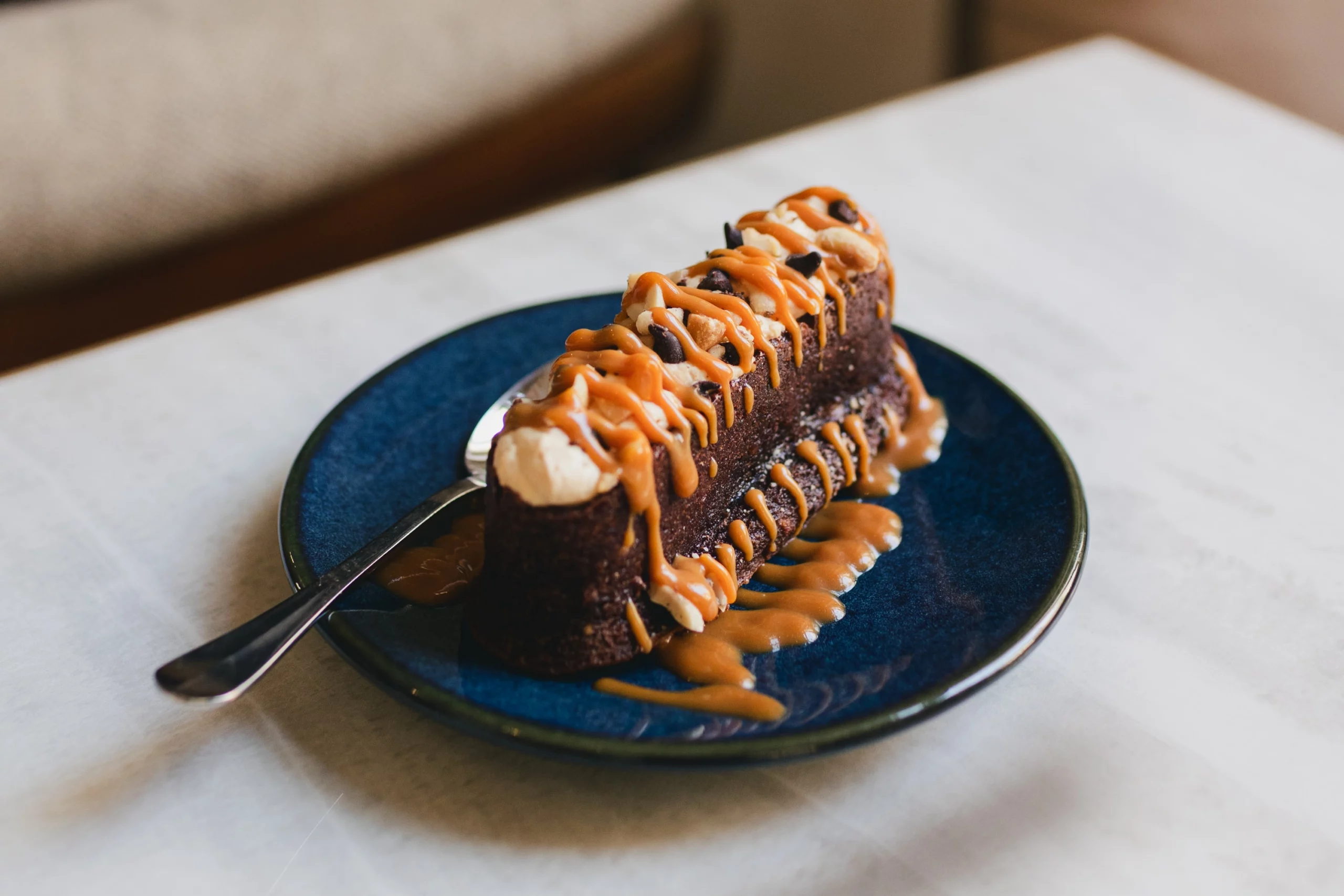 Le gâteau du jour est déposé sur une table avec une cuillère prêt à être dégusté.