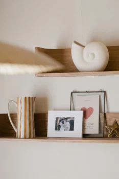 Un livre au page souple tel un album photo est posé sur une étagère dans une maison.