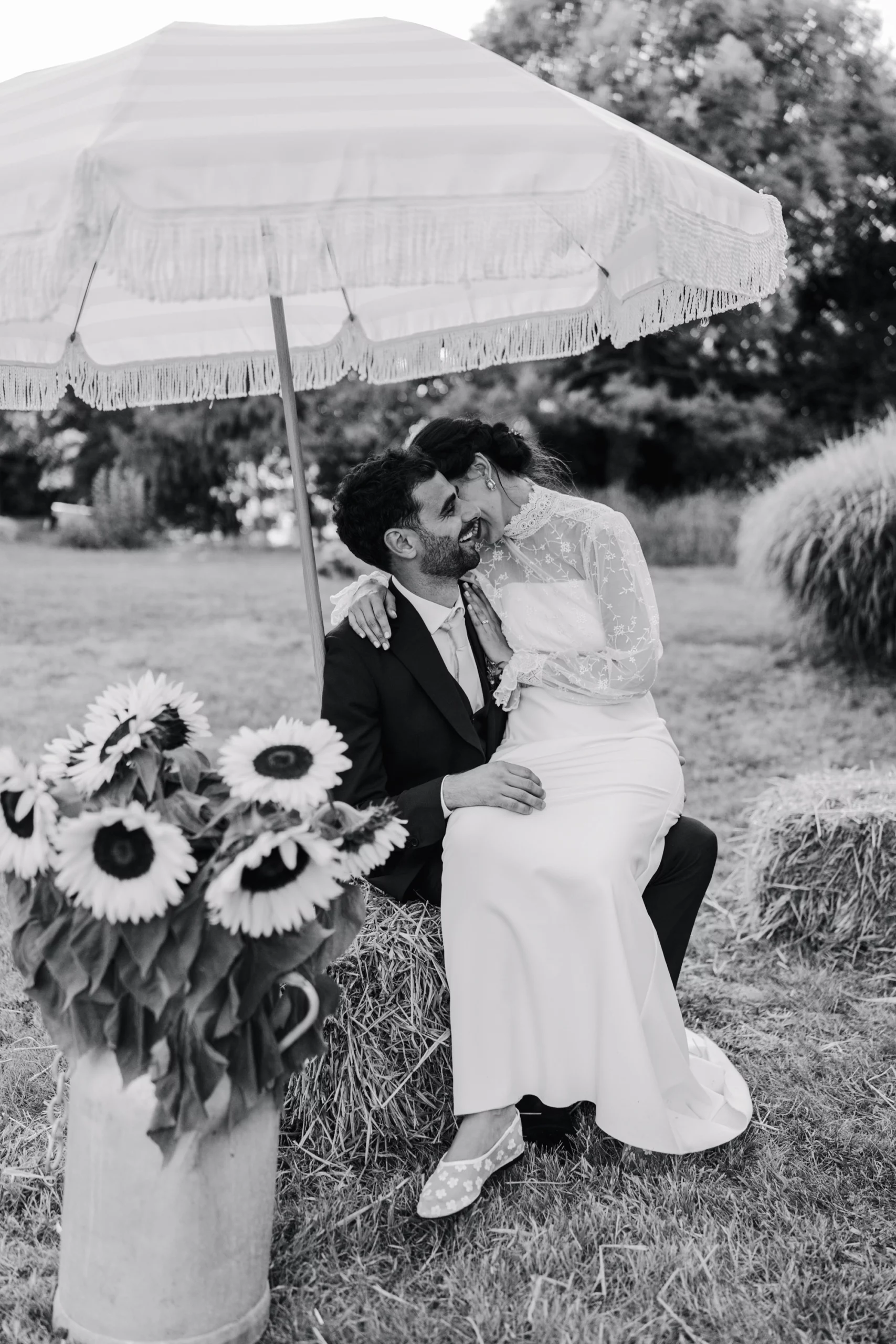 Une femme est assise sur les genoux de son compagnon, elle a le visage caché au creux de son cou et on voit l'homme sourire aux lèvres.