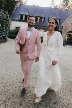 Un couple se tenant la main, court vers la photographe et en arrière-plan le domaine.