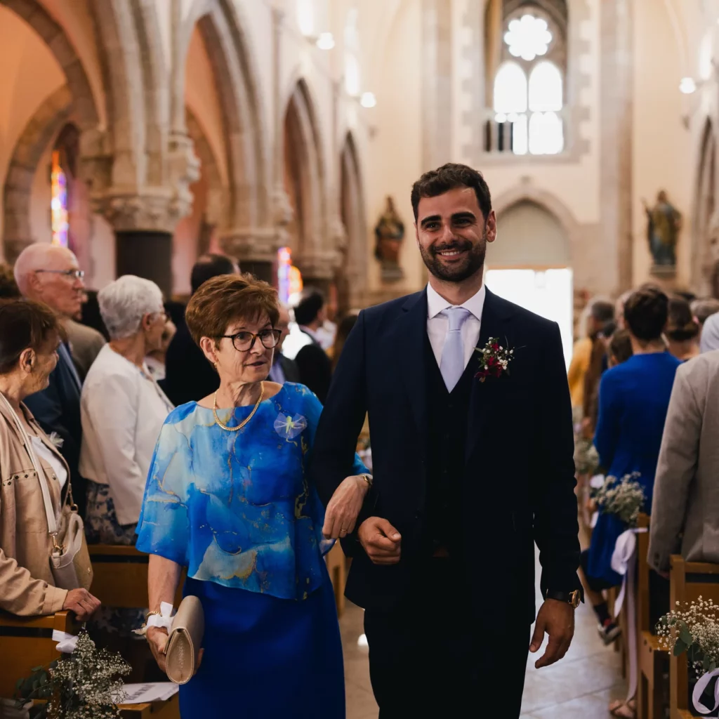 Une homme avance au bras d'une femme dans l'allée de l'église.