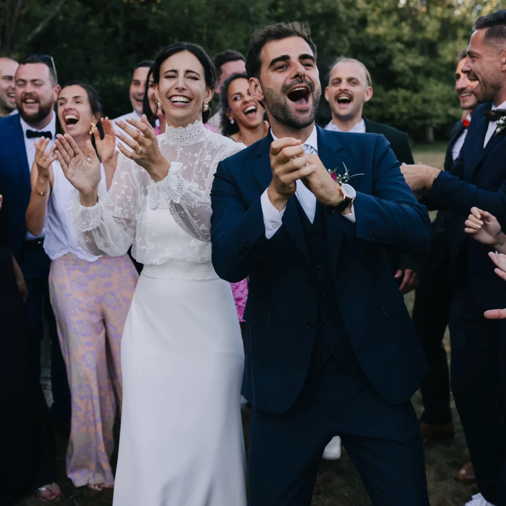 Au premier plan, on y voit un couple de jeunes mariés et au second plan les invités. Frappant dans les mains et les sourires aux lèvres.