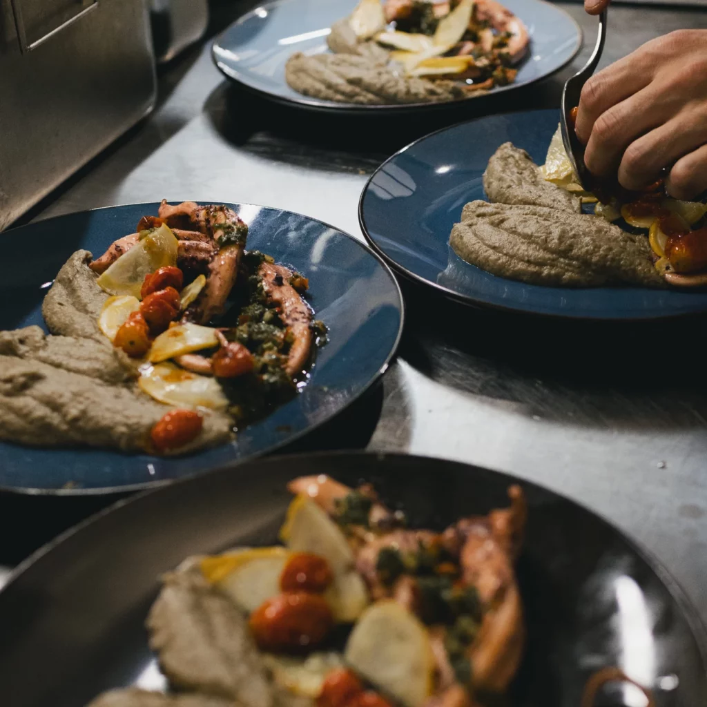 Des mains qui déposes les légumes dans l'assiette du jour.